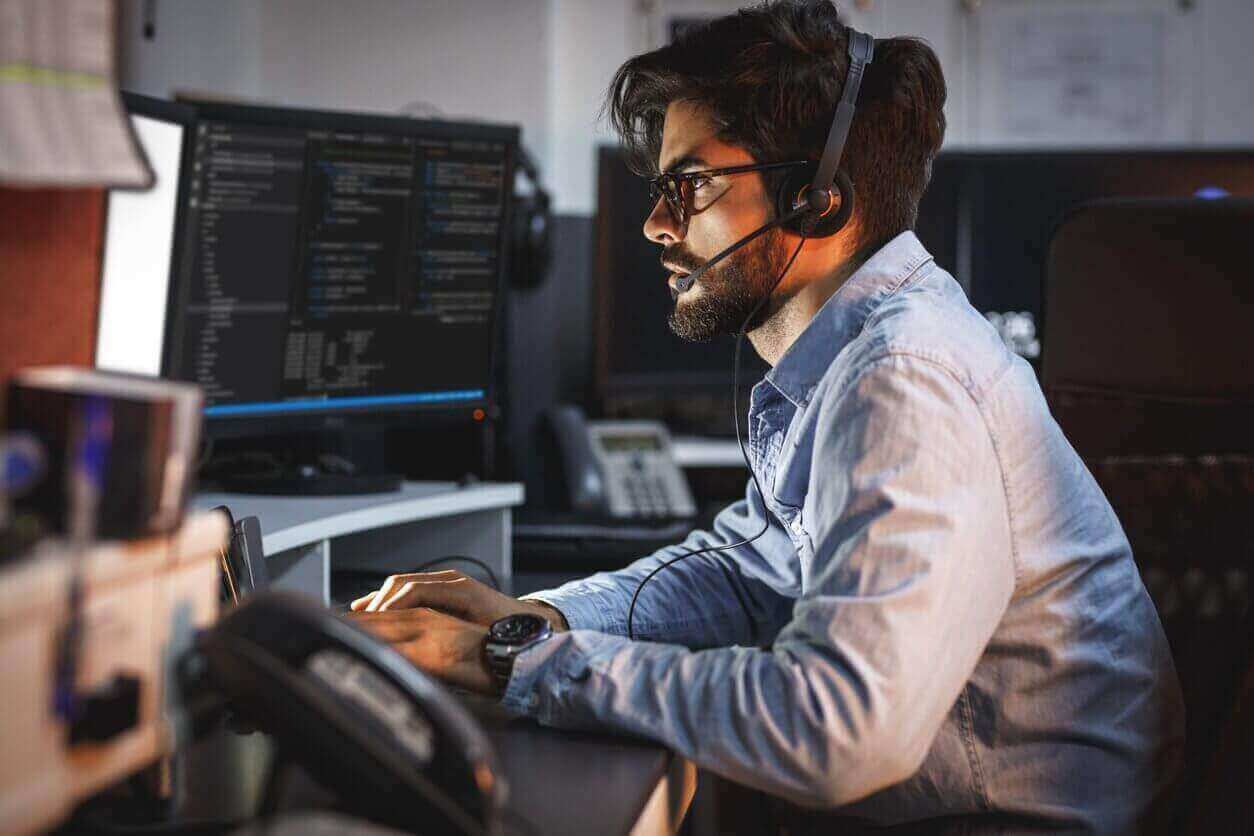 Middle East office worker with headset working at computer. 